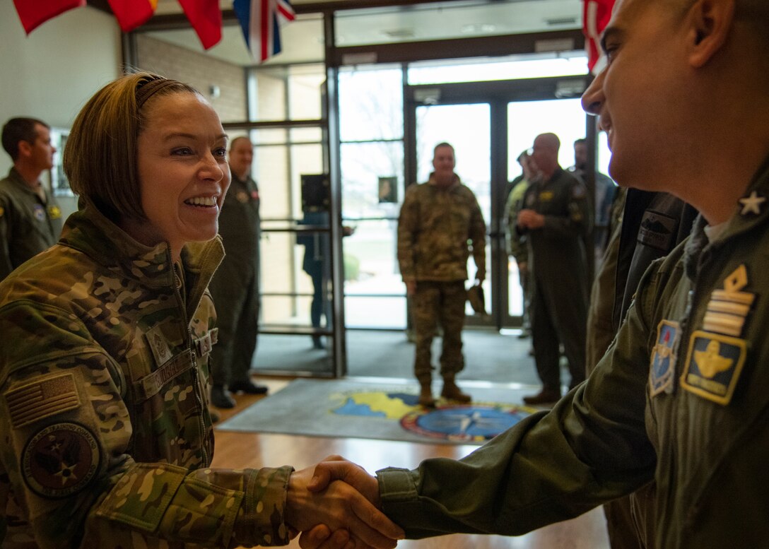 women greeting a man in hallway