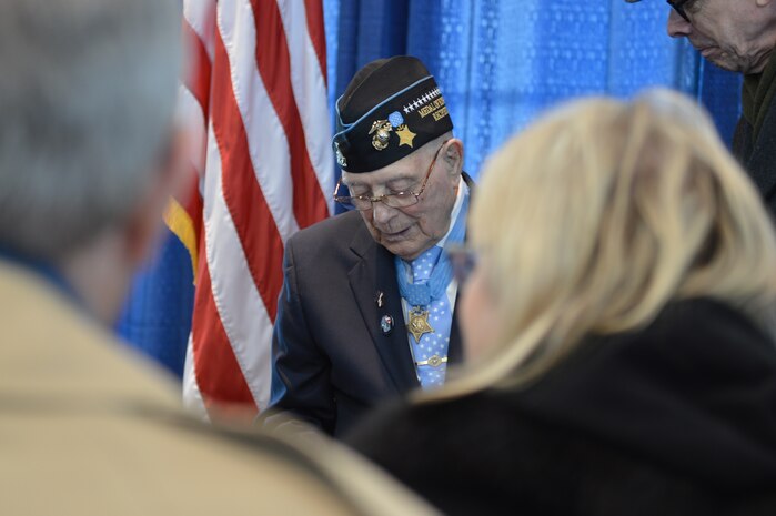 Medal of Honor Recipient, Hershel “Woody” Williams signs commemorative commissioning programs and poses for photos during a reception following the commissioning of the USS Hershel “Woody” Williams (ESB-4).