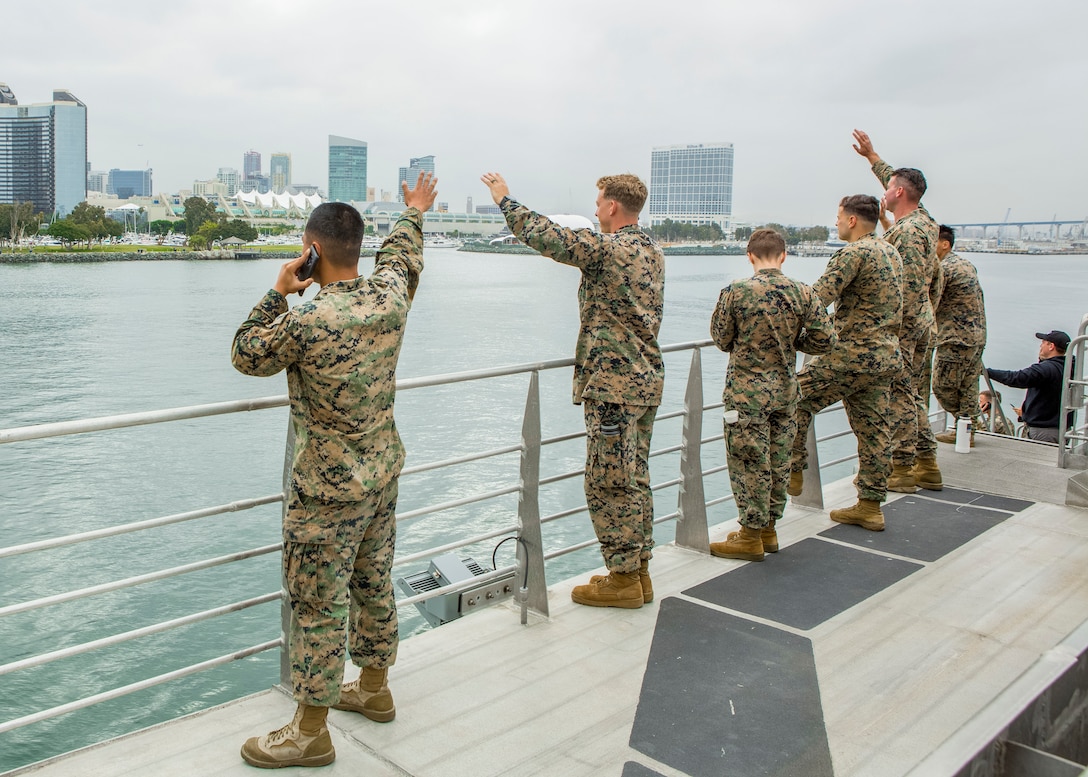 U.S. Marines and Sailors wave from a distance to their friends and family as they depart San Diego, Calif. aboard USNS City of Bismarck (EPF-9) July 2.