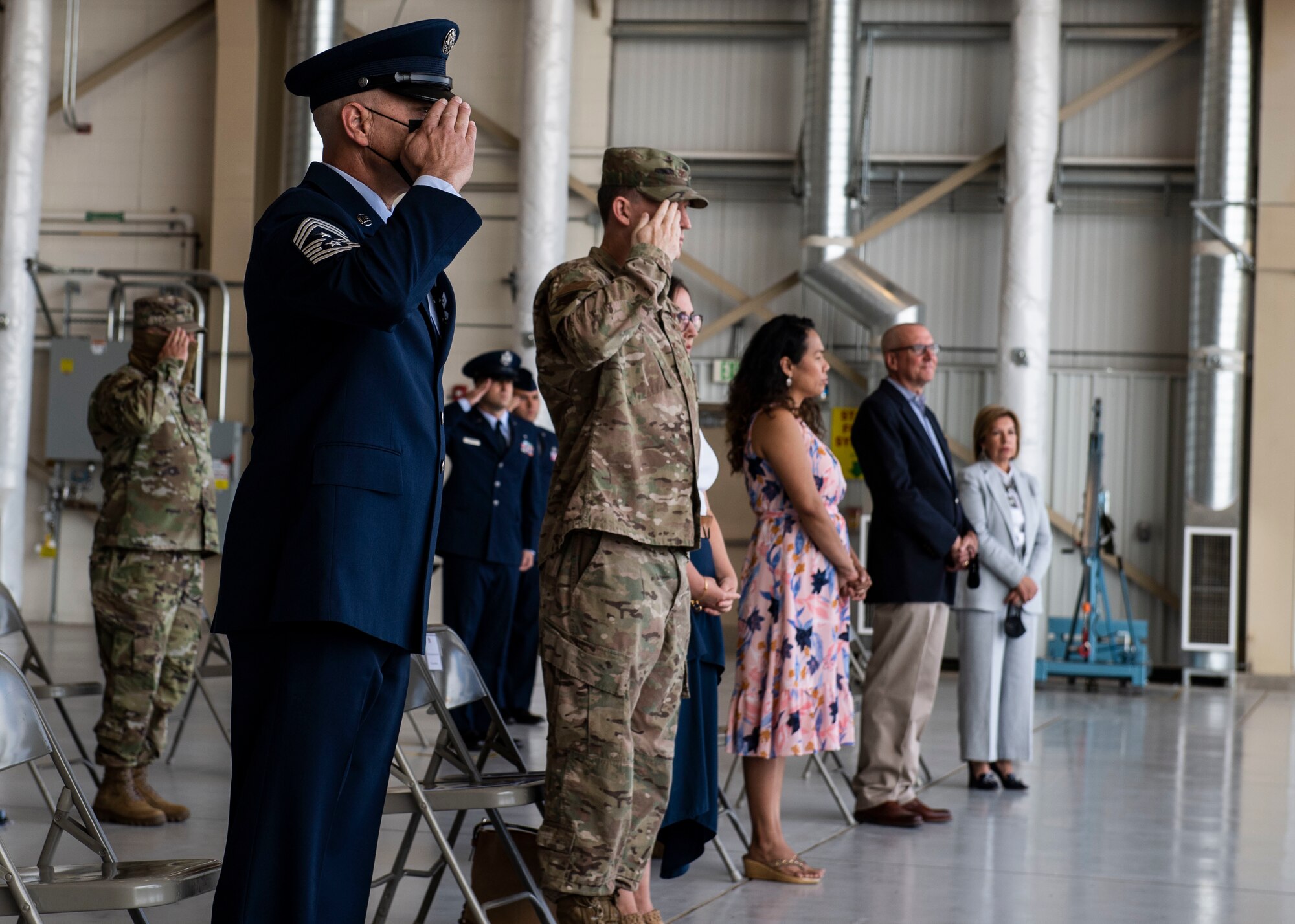 U.S. Air Force Airmen and families stand for the arrival of the official party.