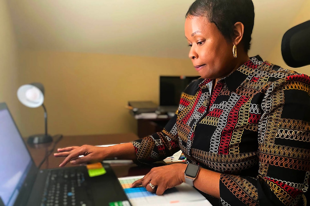 Woman works on laptop.