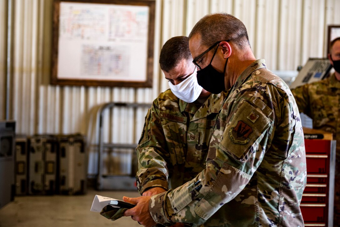 Photo of an Airman briefing a director during an inspection.