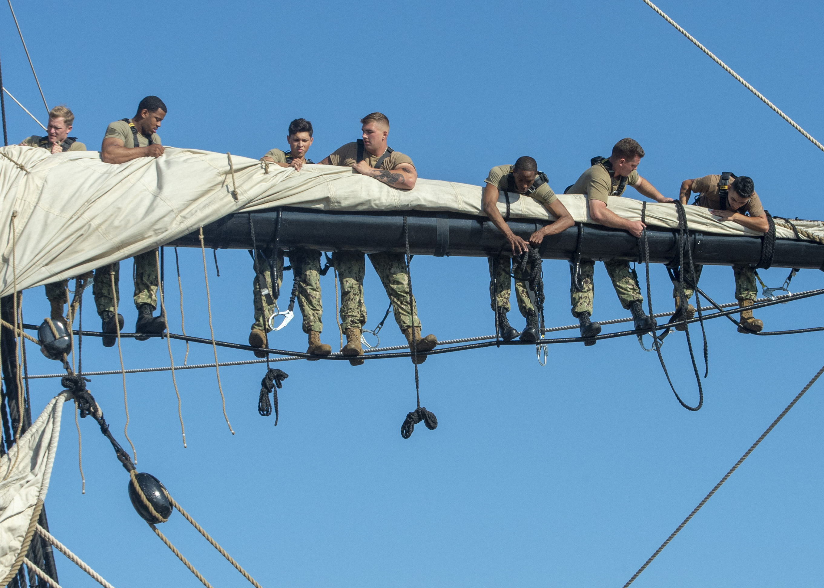 group of sailors hanging around on the sails