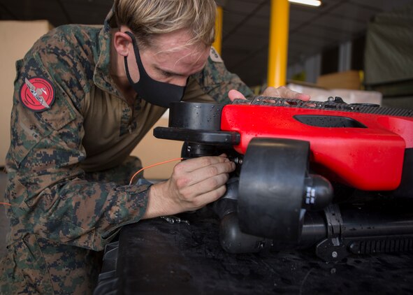 A U.S. Marine removes a Strategic Robotics System Fusion Underwater Unmanned Vehicle out of the water during Littoral Explosive Ordnance Neutralization operations aboard the expeditionary fast transport ship USNS City of Bismarck (EPF 9) at sea, July 15.
