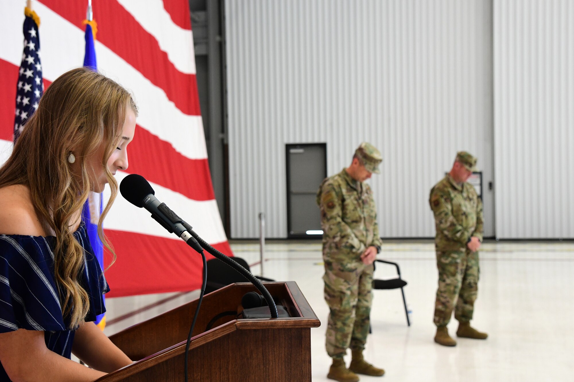 Emma Kirk gives the invocation for her father, Lt. Col. Michael Kirk, 926th Security Forces Squadron, Assumption of Command ceremony, July 24, 2020, Nellis Air Force Base, Nevada. The Assumption of Command ceremony was modified to honor heritage while maintaining current social distancing guidelines. (U.S. Air Force photo by Natalie Stanley)