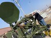 Photo of Samuel Murdock installing an antenna feed