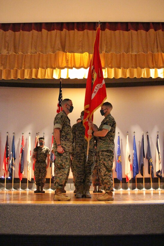 U.S. Marine Lt. Col. Earl Patterson, Goodfellow Marine Detachment outgoing commander, passes the guidon to incoming commander Lt. Col. Arturo Derryberry at the change of command ceremony in the base theater on Goodfellow Air Force Base, Texas, July 17, 2020. The change of command ceremony is a time honored military tradition that signifies the orderly transfer of authority. (Courtesy photo)