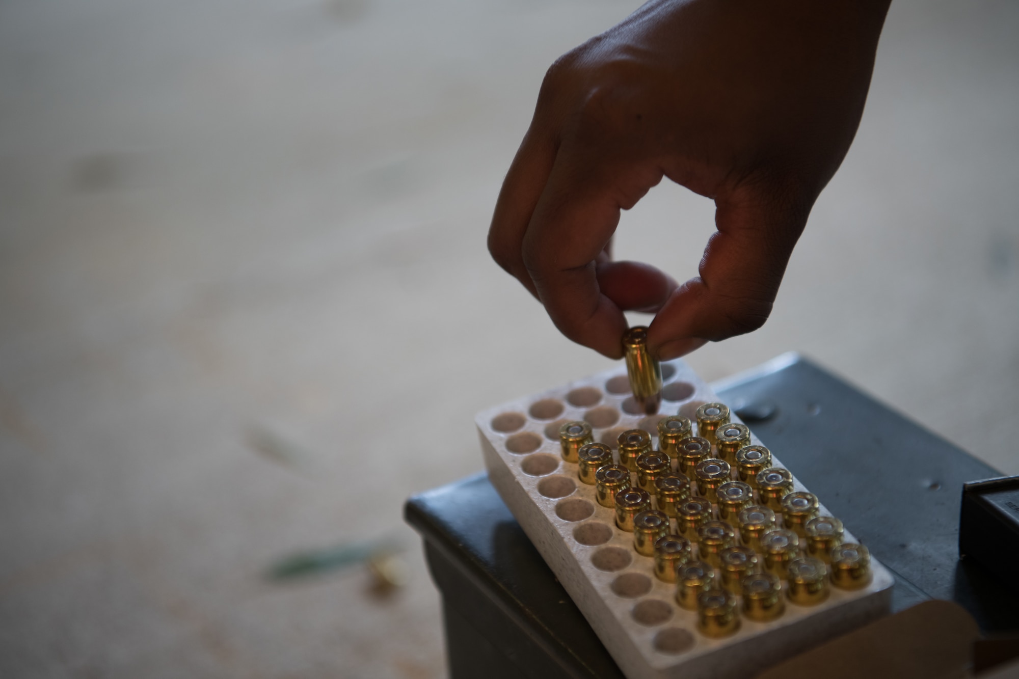 An Air Force Reserve Officer Training Corps cadet removes ammunition from a case while loading a Beretta M9 pistol before qualifying July 9, 2020, at the Combat Arms Training and Maintenance range on Maxwell Air Force Base, Alabama.