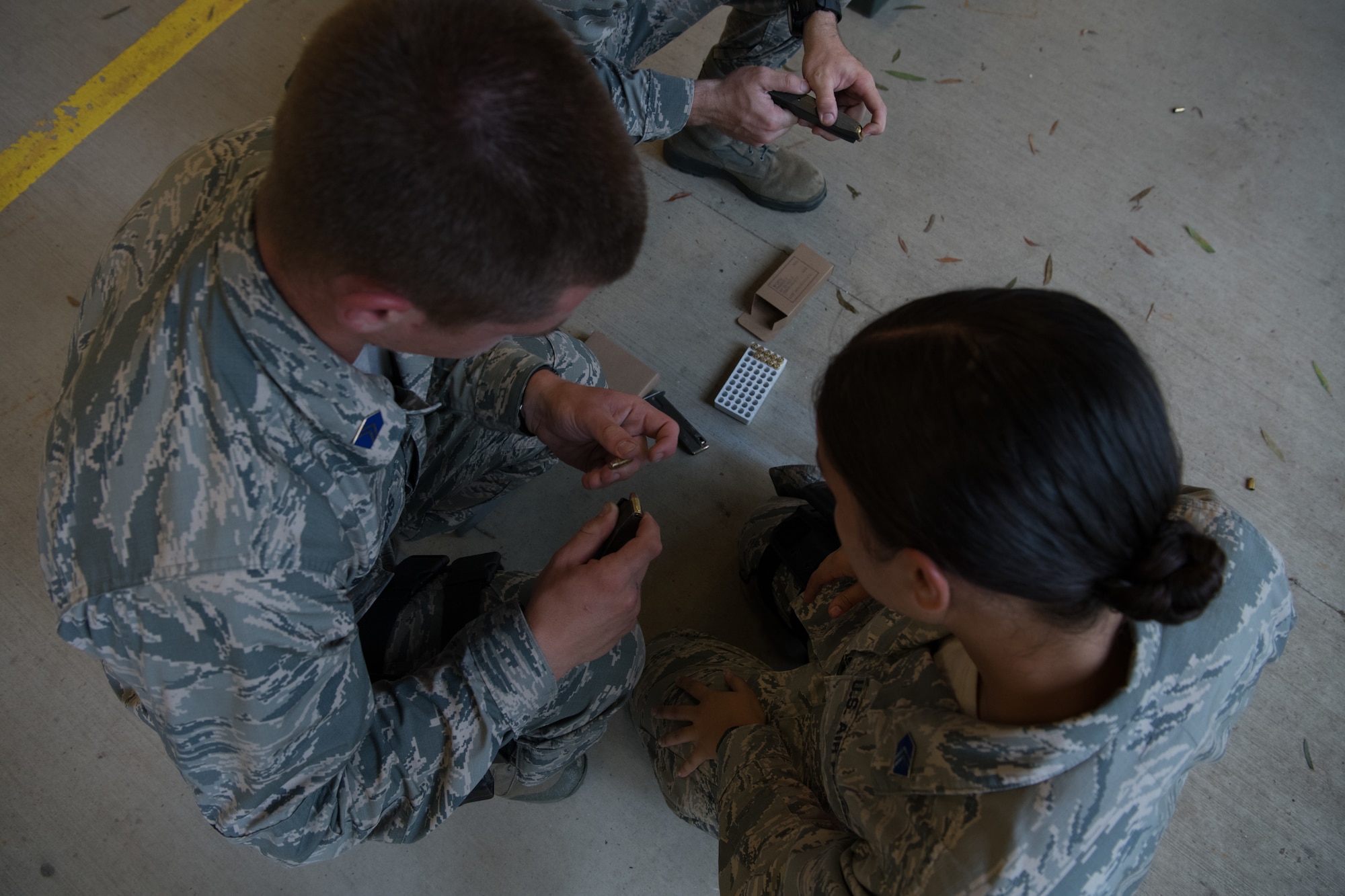 An Air Force Reserve Officer Training Corps cadet demonstrates to a fellow cadet how to properly load ammunition into her handgun’s magazine July 9, 2020, at the Combat Arms Training and Maintenance range on Maxwell Air Force Base, Alabama.