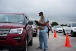 Members of the 59th Medical Wing man a drive through COVID-19 screening clinic on Lackland Air Force Base, June 26, 2020. The drive through clinic was reestablished as part of the protective measures implented as Joint Base San Antonio returns to HPCON Charlie. (U.S. Air Force photo by SSgt Zachary Bumpus)