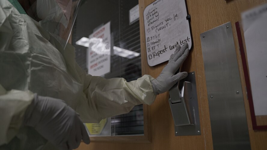 A provider enters a patient room in a COVID-19 intensive care unit at Brooke Army Medical Center, July 17, 2020.