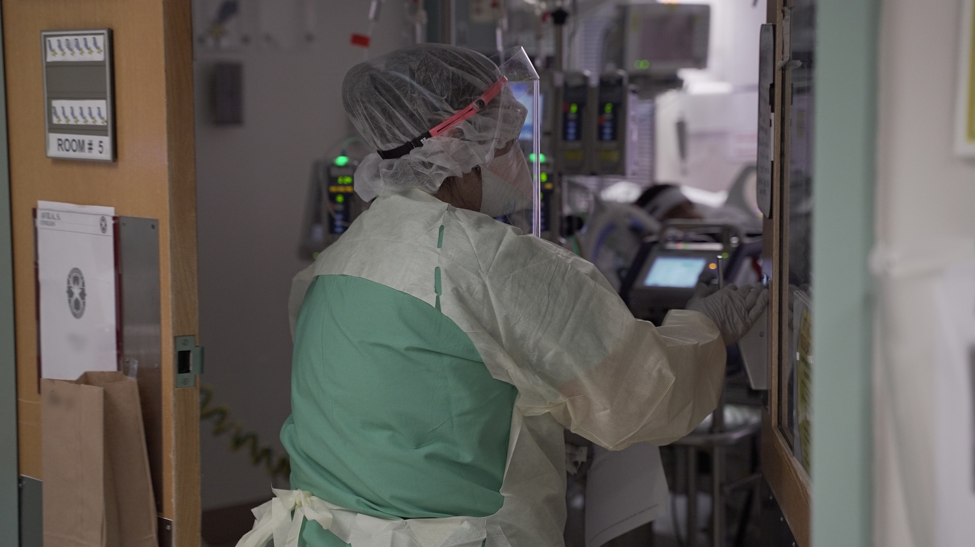 April Pace, a registered nurse, enters a patient room in a COVID-19 intensive care unit at Brooke Army Medical Center, July 17, 2020. (U.S. Army photo by James Camillocci)