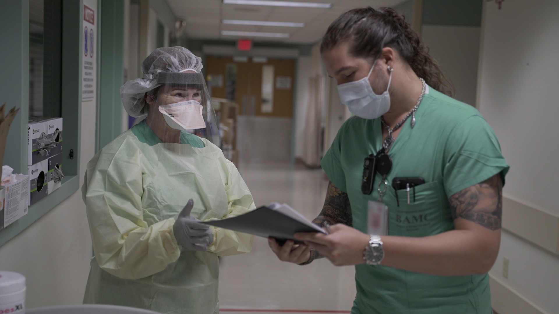 Cesar De La Vega (left) ensures Maj. Kay Bolin properly dons her personal protective equipment in an intensive care unit at Brooke Army Medical Center. (U.S. Army photo by James Camillocci)