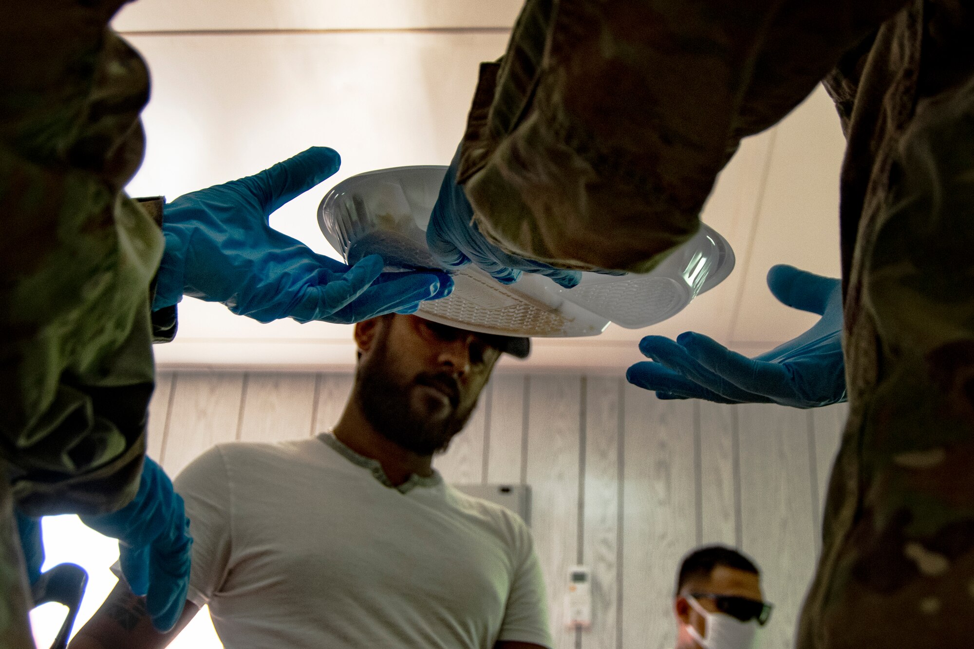 People wearing masks at Ali Al Salem Kuwait working and being served by Airmen.