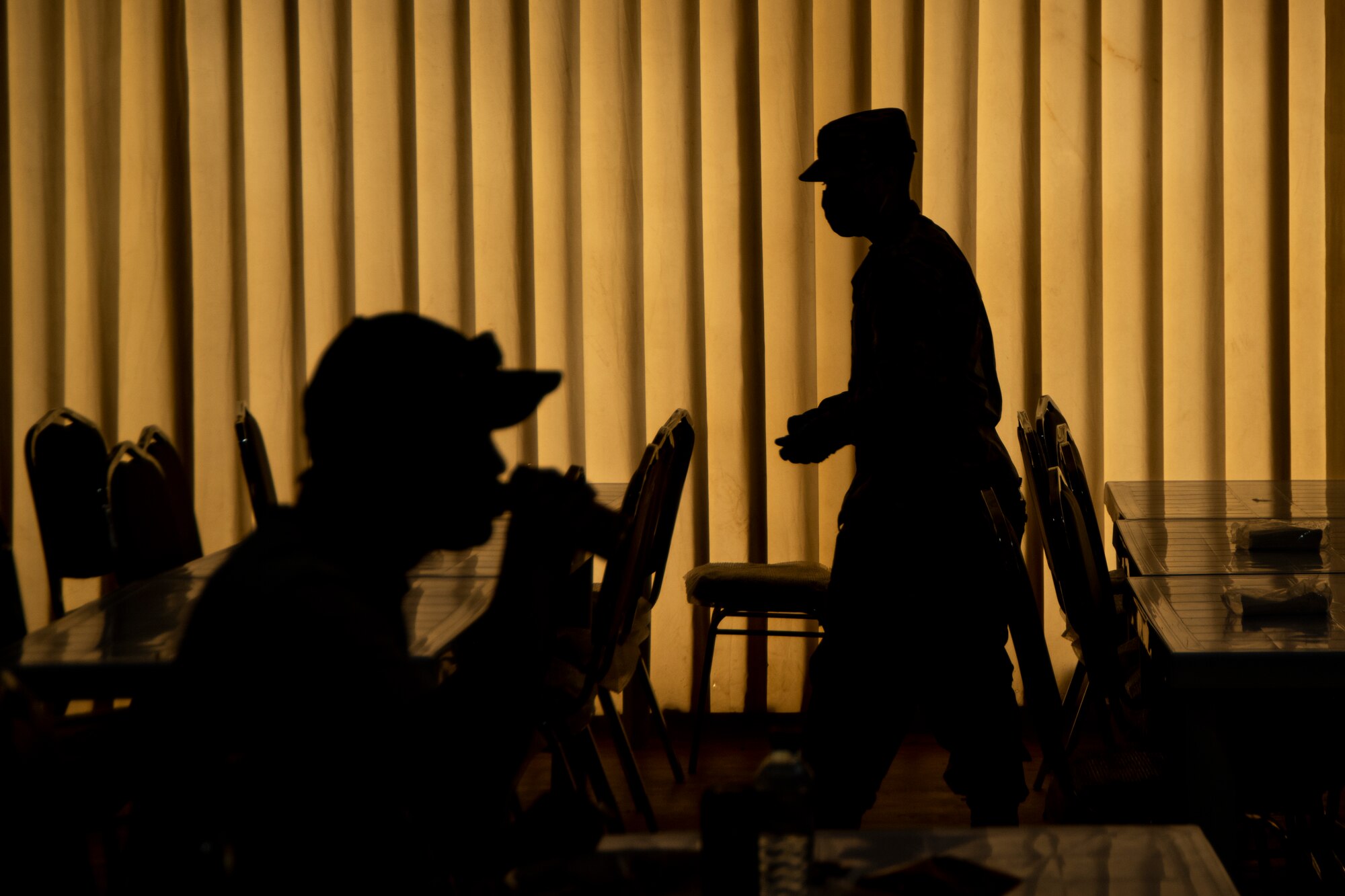 People wearing masks at Ali Al Salem Kuwait working and being served by Airmen.