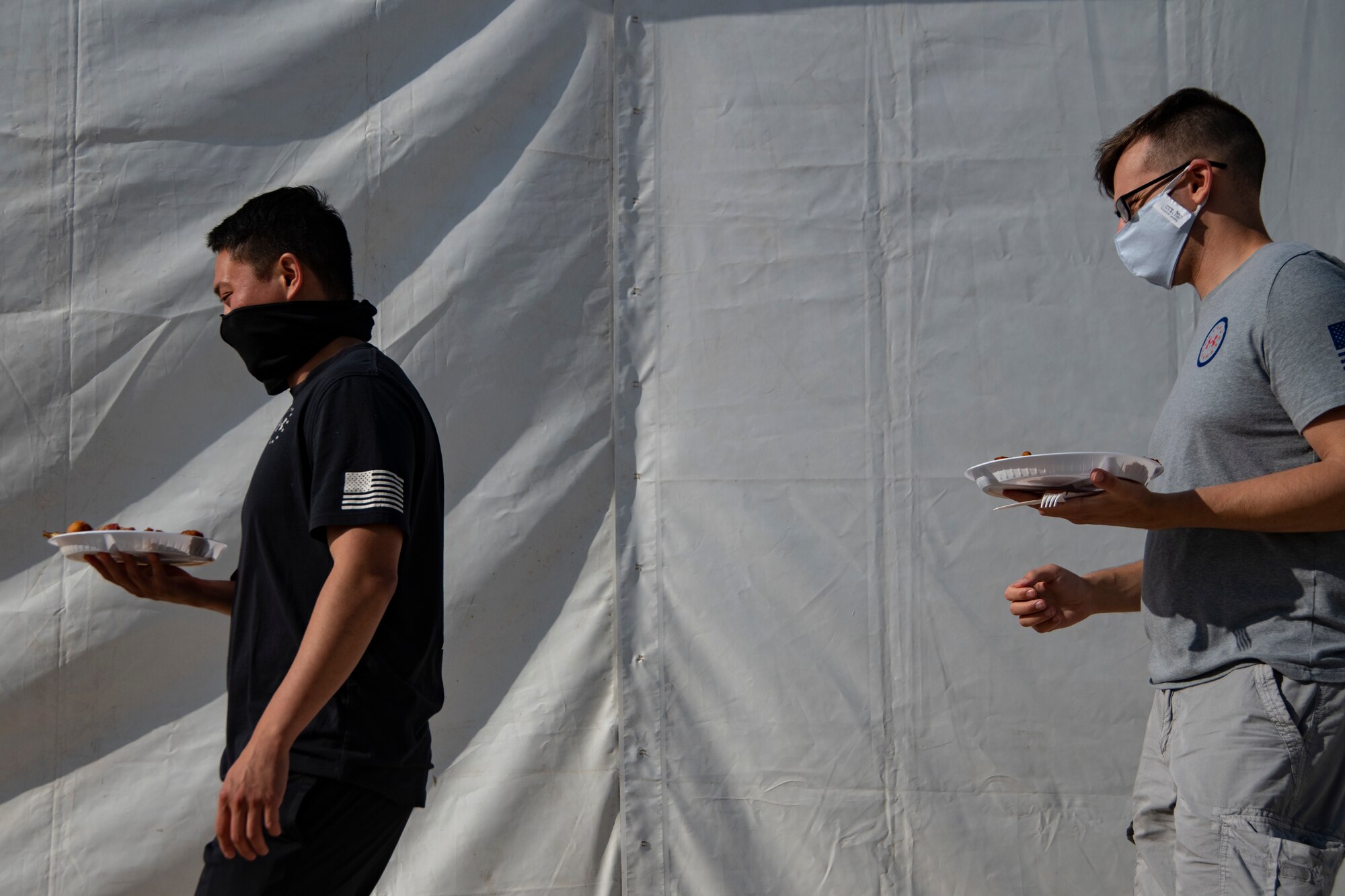 People wearing masks at Ali Al Salem Kuwait working and being served by Airmen.