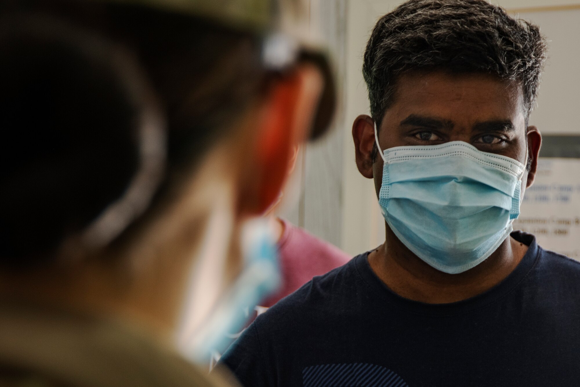 People wearing masks at Ali Al Salem Kuwait working and being served by Airmen.