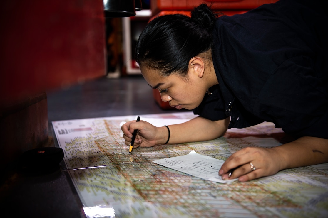 sailor planning routes on the floor, drawing on the map