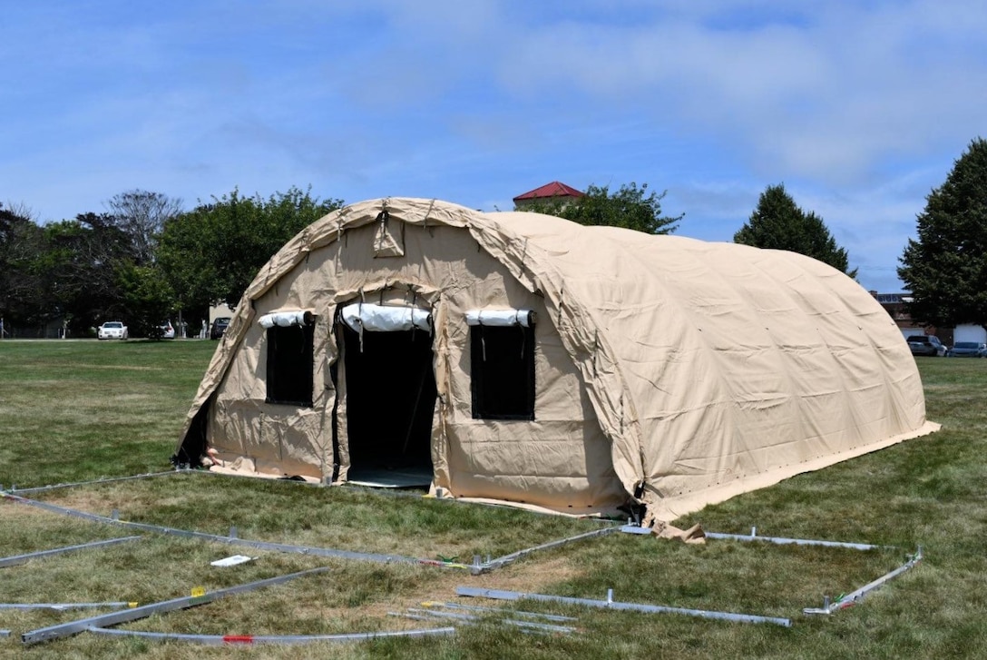 The first of five Alaska Medical Shelters awaits use after NMRTC employees raise the structure at the Navy’s medical clinic in Newport, Rhode Island, on July 7, 2020. The Defense Logistics Agency partnered with Air Force and Navy medical to provide shelters for COVID-19 screening at naval medical facilities in the Northeast.