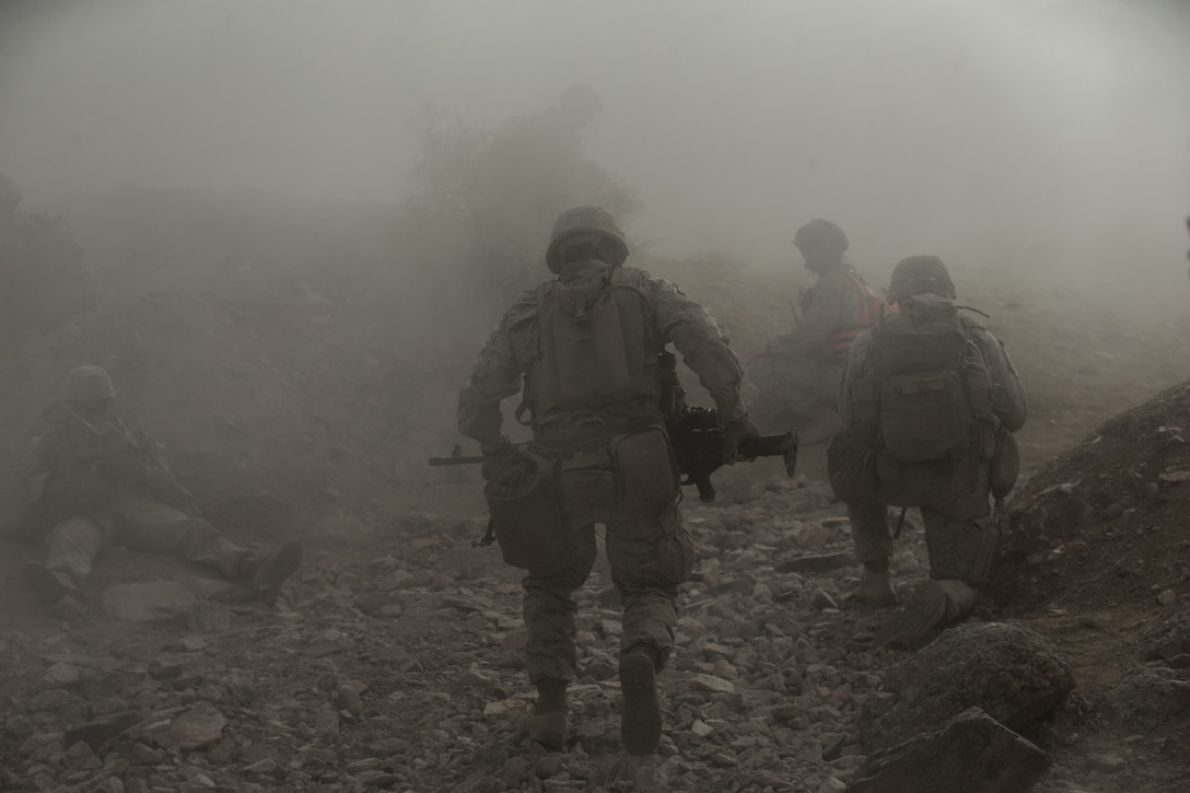 U.S. Marines assault an objective through a Bangalore torpedo breach while participating in range 400 at Marine Air Ground Combat Center Twentynine Palms, Calif., July 18.