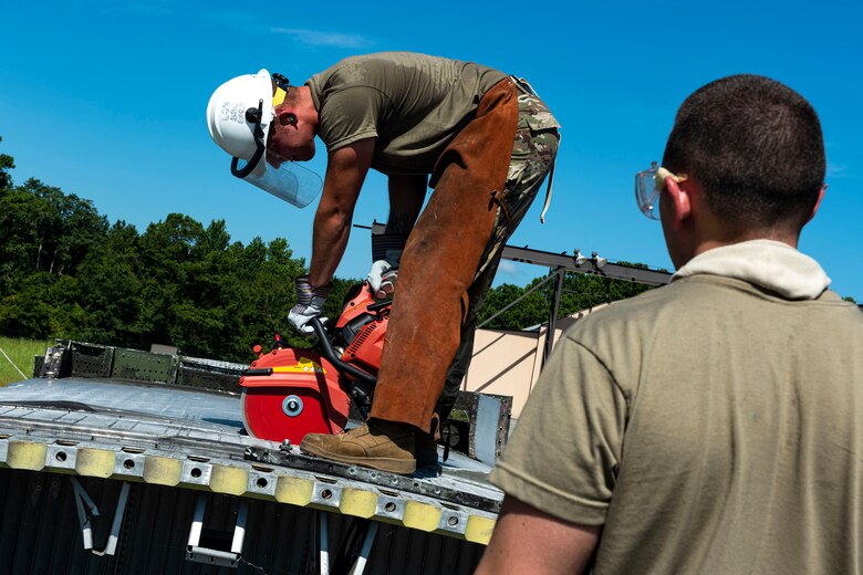 Photo of an Airman cutting into an HC-130J.