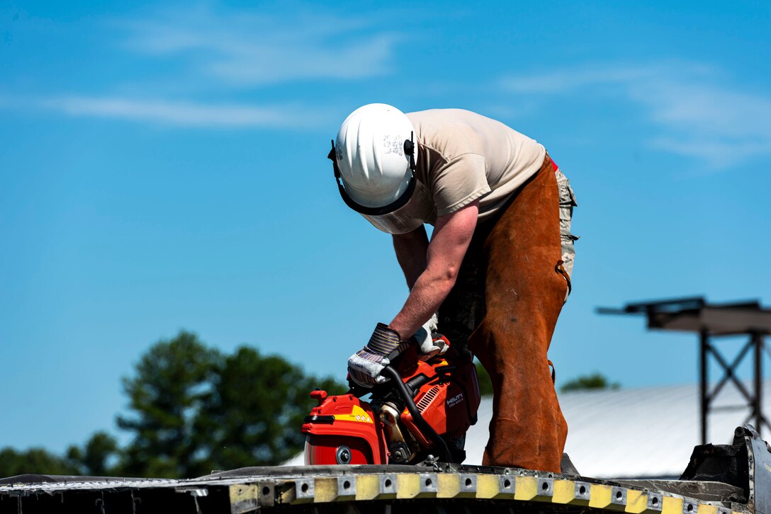 Photo of an Airman cutting into an HC-130J.