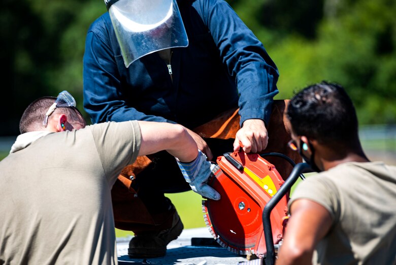 Photo of Airmen changing out a saw blade.