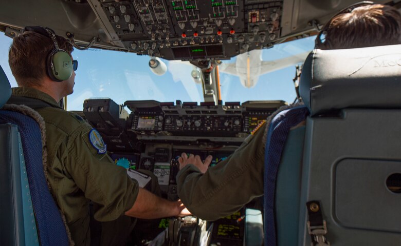 Capt. Shelby Foster, 7th Airlift Squadron (AS) pilot, right, flies a C-17 Globemaster III during an air refueling training sortie led by Lt. Col. Matt McNulty, 7th AS pilot, left, near Salt Lake City, Utah, July 27, 2020. The 7th AS is participating in a small group tryout to test a new aircrew-training program that is attempting to focus training and make it more effective and efficient. (U.S. Air Force photo by Senior Airman Tryphena Mayhugh)
