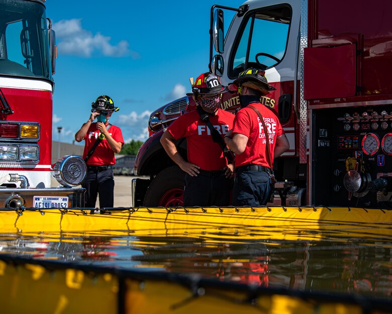 Firefighters assigned to the 910th Fire Department discuss training procedures, July 24, 2020, on the flightline at Youngstown Air Reserve Station. Airmen from the FD were completing Seasonal Training requirements for pump operations. ST is a program where Airmen raise their skill level from apprentice to a journeyman.