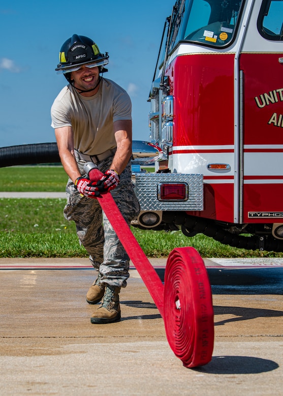 Senior Airman Paul Volpe, a firefighter with the 910th Fire Department, unrolls a fire hose, July 24, 2020, on the flightline at Youngstown Air Reserve Station. Volpe is one of 10 Airmen at the station who are completing their Seasonal Training this summer. ST is a program where Airmen raise their skill level from apprentice to a journeyman.