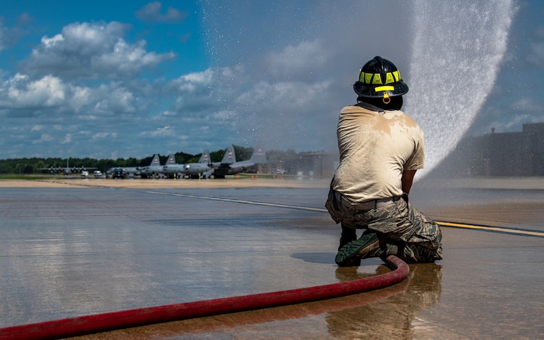 A firefighter with the 910th Fire Department sprays water from a fire hose, July 24, 2020, on the flightline at Youngstown Air Reserve Station. Airmen from the station were completing their Seasonal Training requirements for pump operations. ST is a program where Airmen raise their skill level from apprentice to a journeyman.