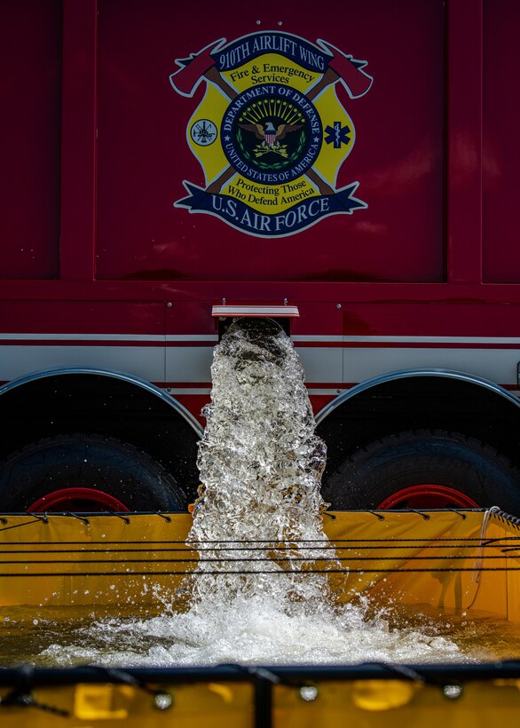 Water releases from a fire truck assigned to the 910th Fire Department into a mobile water supply, July 24, 2020, on the flightline at Youngstown Air Reserve Station. Airmen from the FD are completing Seasonal Training requirements for pump operations. ST is a program where Airmen raise their skill level from apprentice to a journeyman.