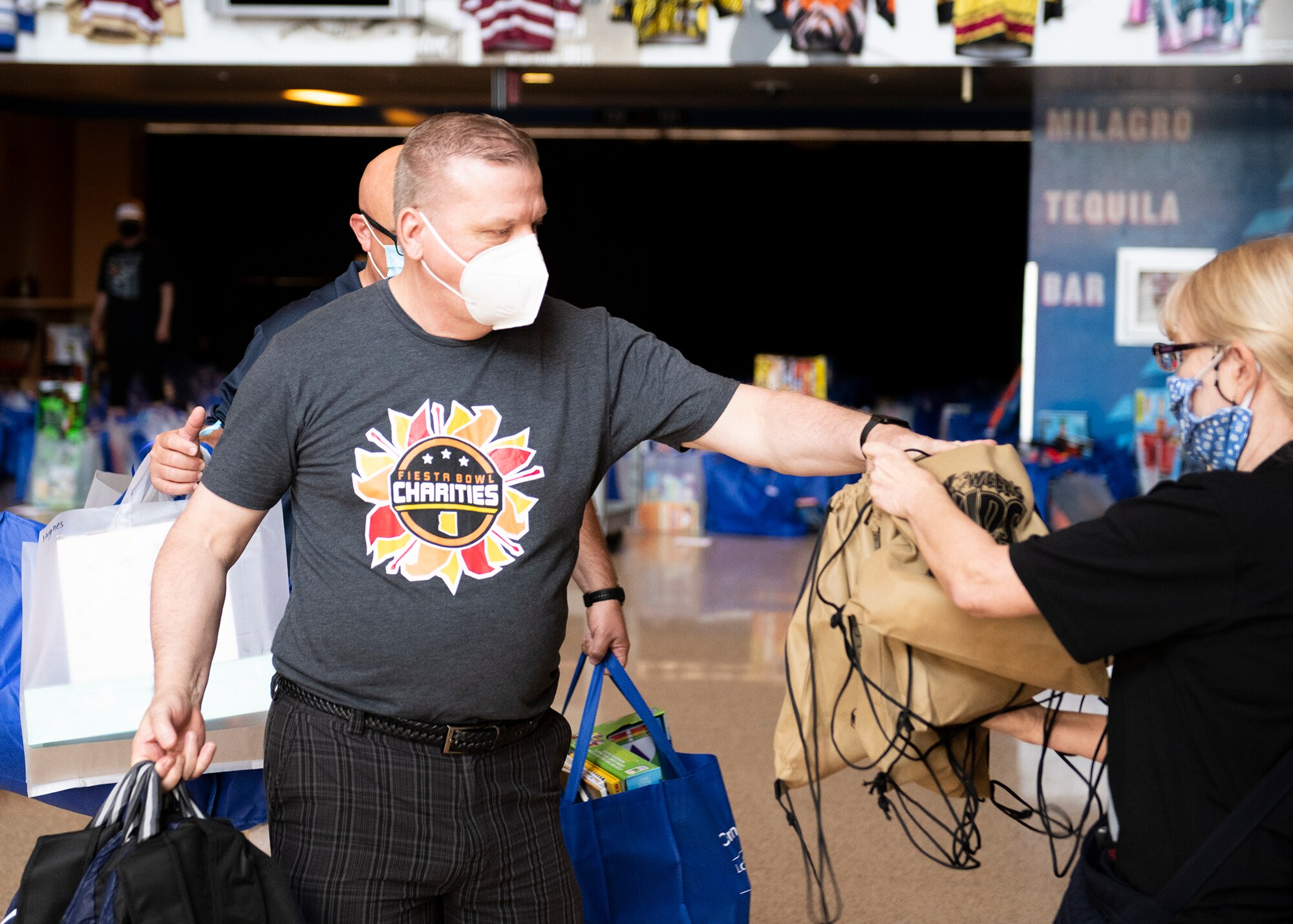 Jimbo Norton, Back to School Bash volunteer and 56th Communication Squadron resource advisor, distributes bags to the Back to School Bash drive-thru area July 23, 2020, at the Gila Bend Arena in Glendale, Ariz.