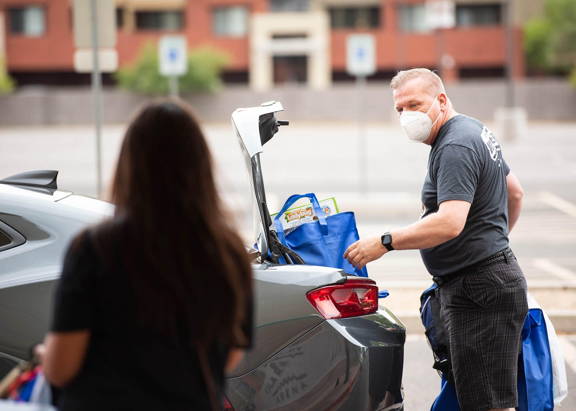 Jimbo Norton, Back to School Bash volunteer and 56th Communication Squadron resource advisor, loads a car during the Back to School Bash drive-thru July 23, 2020, at the Gila Bend Arena in Glendale, Ariz.