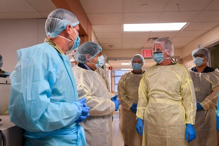 People swathed in medical gear speak.