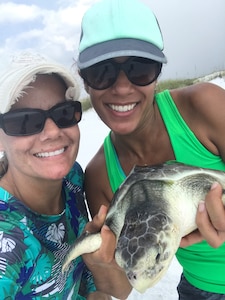 Erica Lee, Air Force Civil Engineer Center Support Program manager for Eglin Natural Resources, and Amanda Robydek, Leidos Environmental Scientist, hold a Kemp's ridley sea turtle during one of many acoustic and satellite tagging events.