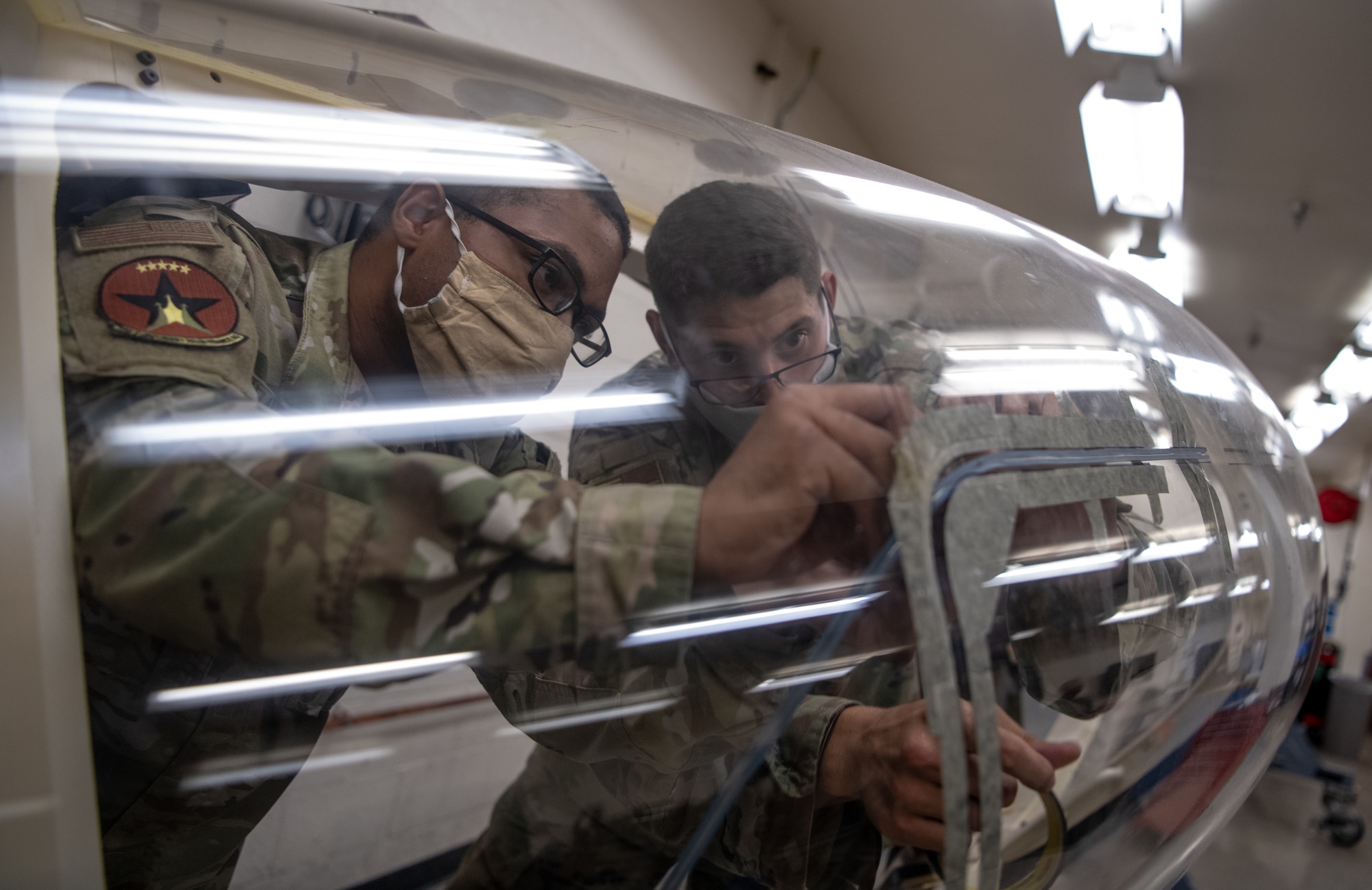 Senior Airman Matthew Romano, 56th Component Maintenance Squadron aircrew egress systems journeyman (left), trains Airman 1st Class Delwyn Travillion, 56th CMS aircrew egress systems apprentice, on the installation of a flexible linear shaped charge (FLSC) July 13, 2020, at Luke Air Force Base, Ariz. The FLSC install is a 120-hour process, and the charge must be replaced every three years. Training of this task is essential to the overall integrity of the F-35A Lightning II canopy. (U.S. Air Force photo by Airman 1st Class Dominic Tyler)