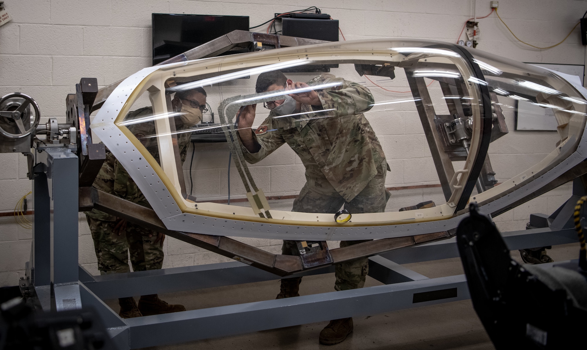 Senior Airman Matthew Romano, 56th Component Maintenance Squadron aircrew egress systems journeyman, (left) trains Airman 1st Class Delwyn Travillion, 56th Component Maintenance Squadron aircrew egress systems apprentice, on the installation of a flexible linear shaped charge (FLSC) July 13, 2020, at Luke Air Force Base, Ariz. The egress shop implemented a 3D printed F-35A Lightning II canopy to enhance training efficiency and reduce training time. (U.S. Air Force photo by Airman 1st Class Dominic Tyler)