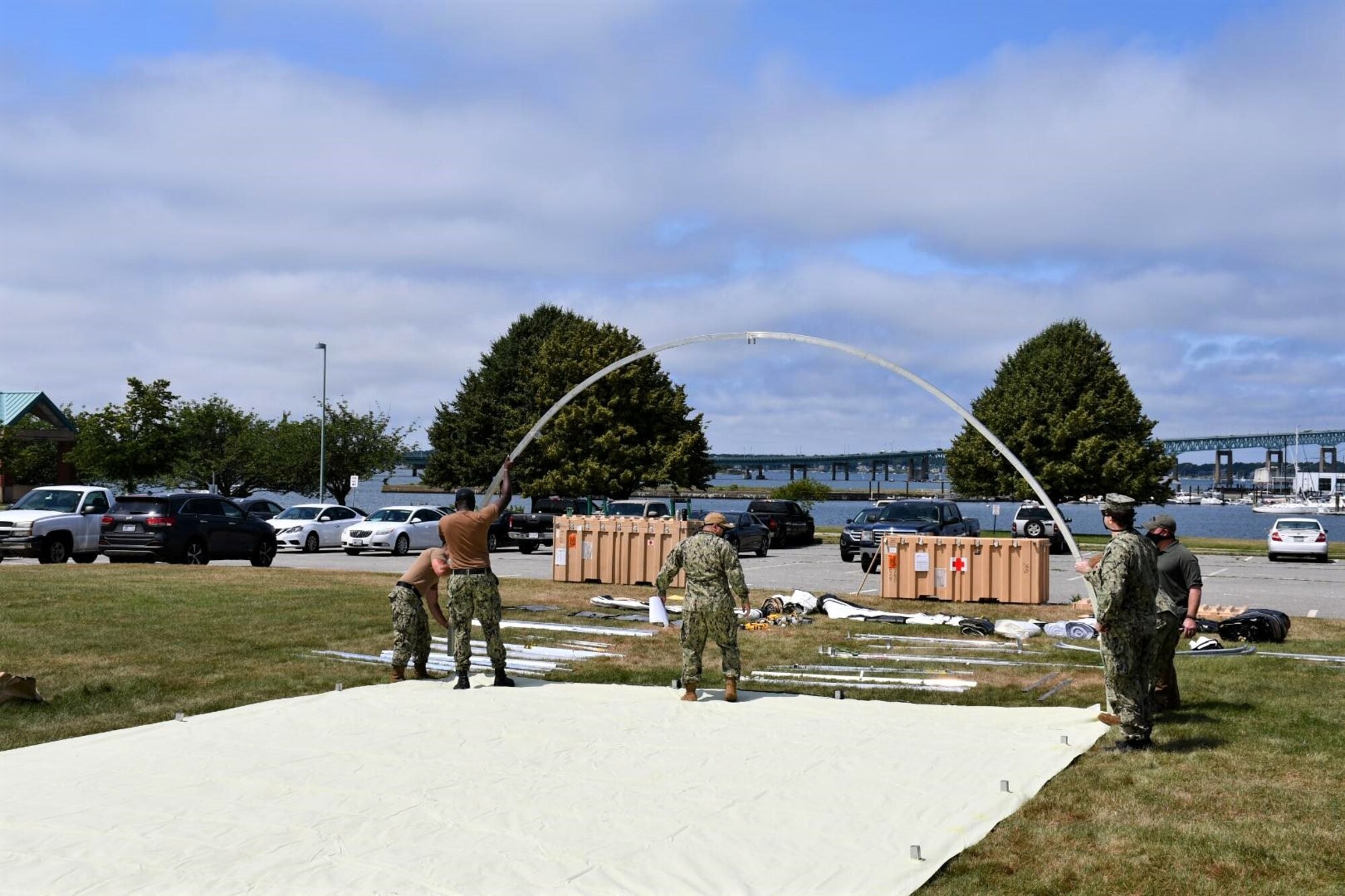NMRTC employees raise the first of five shelters at the Navy’s medical clinic in Newport, Rhode Island, on July 7, 2020. The Defense Logistics Agency partnered with Air Force and Navy medical to provide shelters for COVID-19 screening at naval medical facilities in the Northeast.
