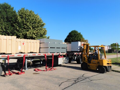 Steve Stringham, NMRTC clinic staff member, operates the forklift to offload shelters after their arrival in Newport. The Defense Logistics Agency partnered with Air Force and Navy medical to provide shelters for COVID-19 screening at naval medical facilities in the Northeast.