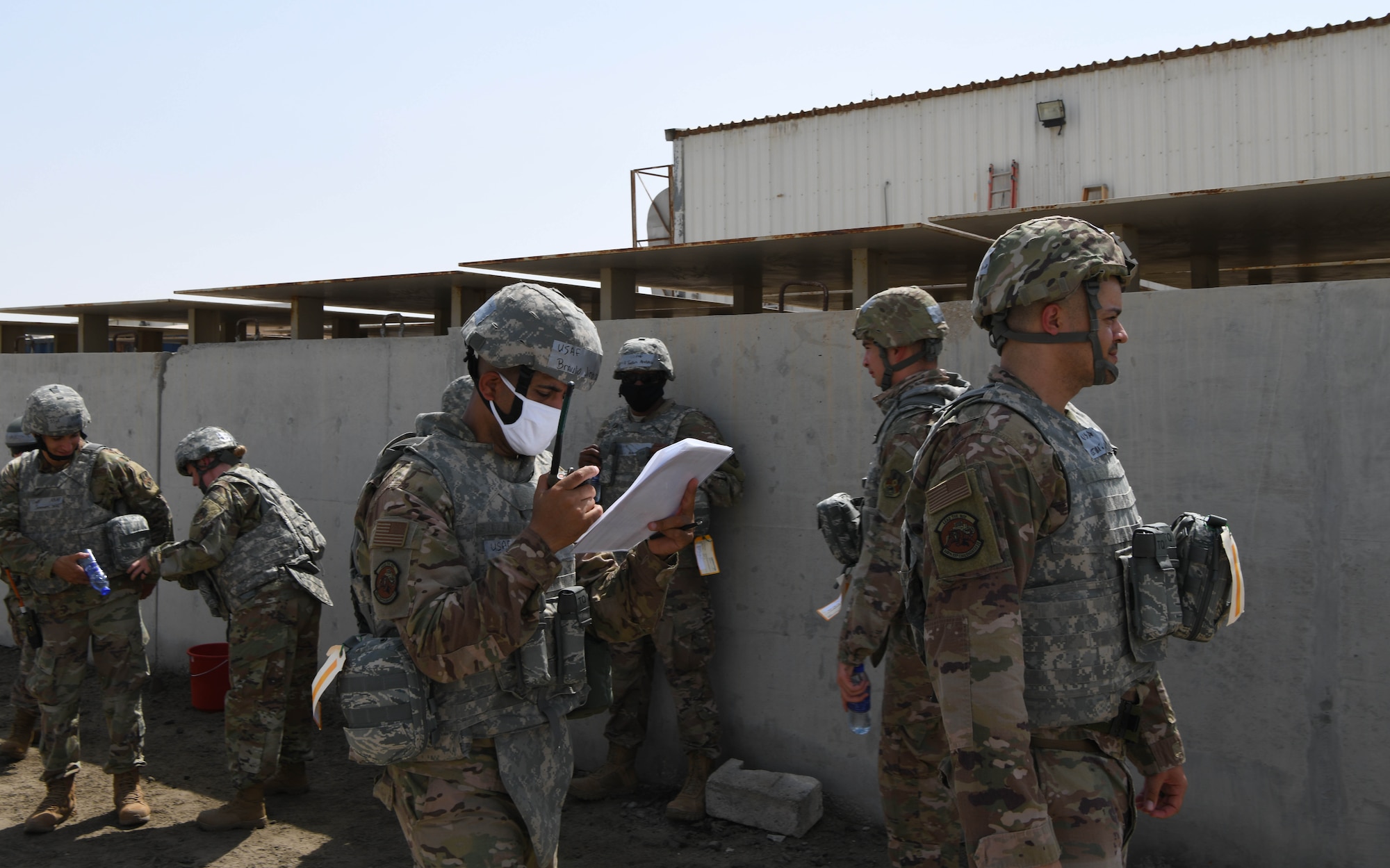Airmen from the 380th Expeditionary Civil Engineer Squadron go through accountability checklists after a bunker dive during a rotational exercise July 21, 2020, at Al Dhafra Air Base, United Arab Emirates. The exercise gives deployers an opportunity to execute some of the techniques taught to them during training at home station. (U.S. Air Force photo by Tech. Sgt. Charles Taylor)