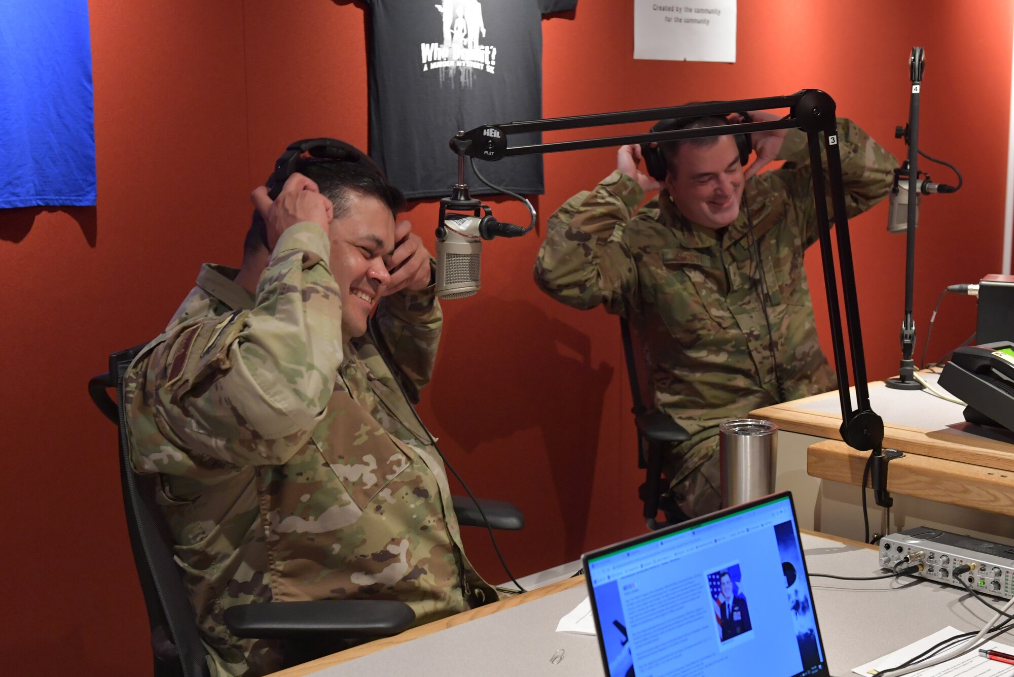 Airmen taking off headphones in a radio station studio.