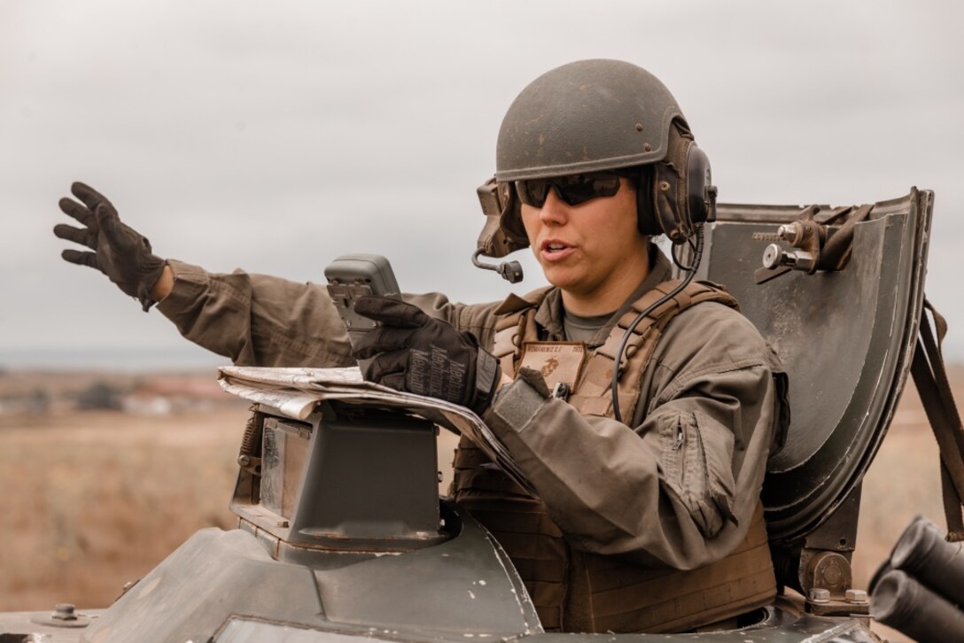U.S. Marine Sgt. Chelsea Romanowiz, a student with the Assault Amphibian Vehicle Commander Course, Assault Amphibian School, directs a fellow Marine during mounted land navigation training in the Oscar Two Training Area on Marine Corps Base Camp Pendleton, California, July 22, 2020. The Vehicle Commander Course is used to train intermediate level Marines on the responsibilities of an AAV commander, with a focus on crew gunnery, direction and supervision. Romanowiz is a native of Jacksonville, Florida. (U.S. Marine Corps photo by Lance Cpl. Alison Dostie)