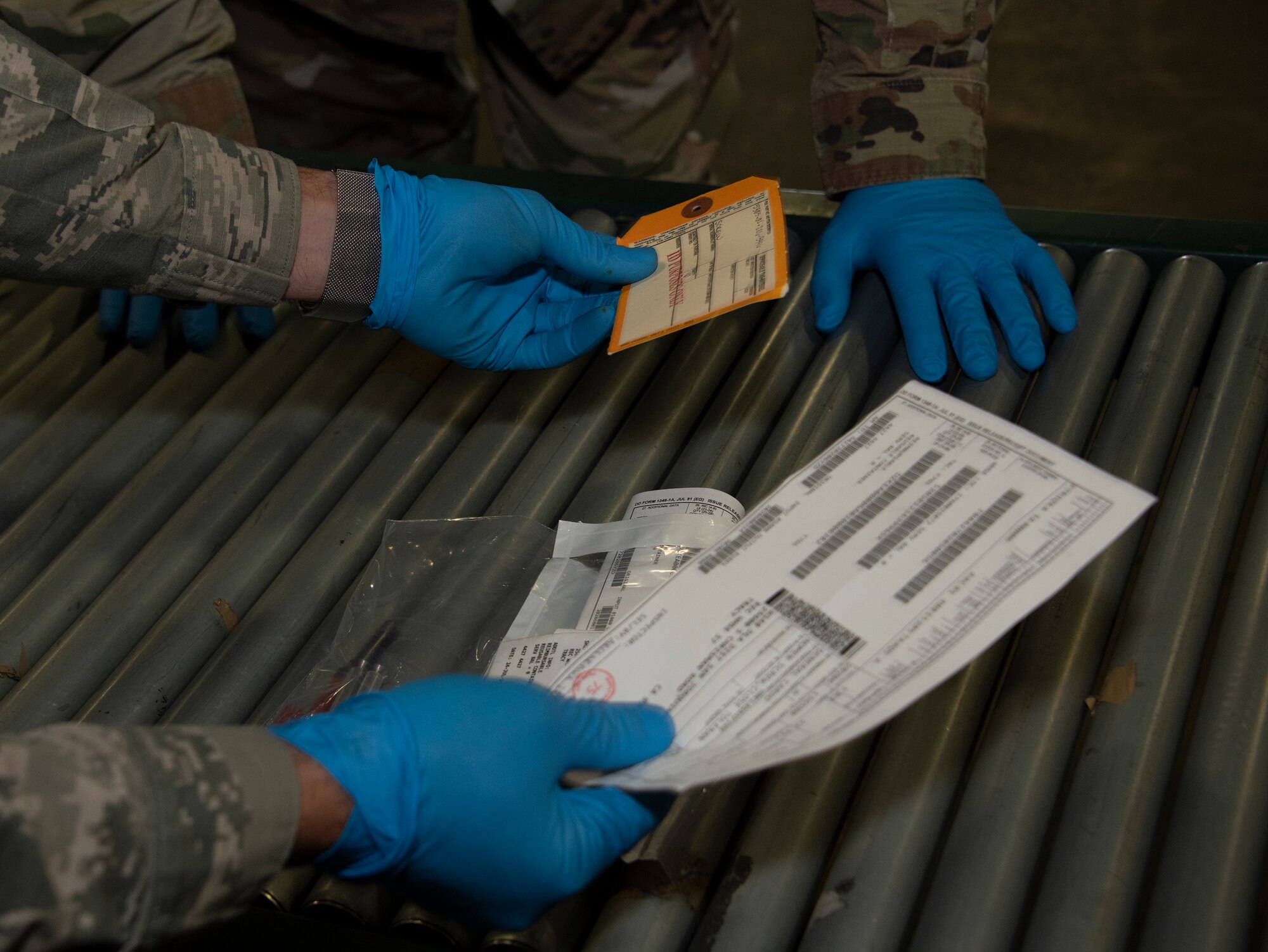 U.S. Air Force Airman 1st Class Yaser Belal, left, 60th Aerial Port Squadron packing and crating technician, shows Chief Master Sgt. Robert Schultz, 60th Air Mobility Wing command chief, the various labels that are affixed to shipment containers during Leadership Rounds July 24, 2020, at Travis Air Force Base, California. The 60th APS is the United States Transportation Command's primary west coast aerial port providing global and passenger distribution for the United States and its Allies. The Leadership Rounds program provides 60th AMW leadership an opportunity to interact with Airmen and get a detailed view of each mission performed at Travis AFB. (U.S. Air Force photo by Heide Couch)
