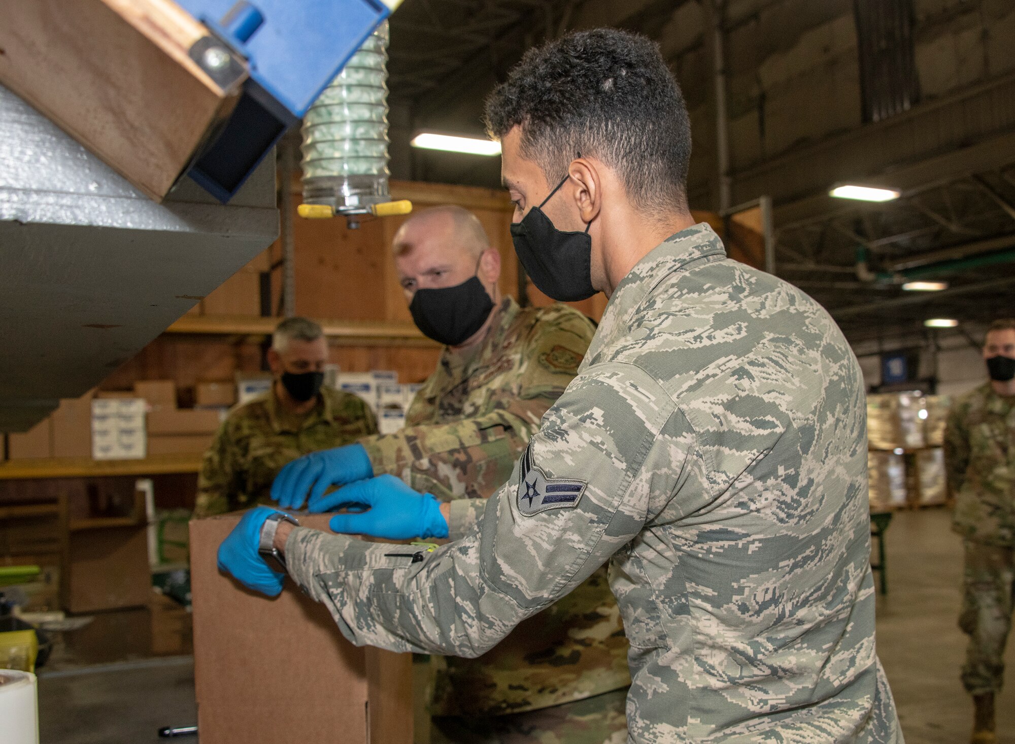 U.S. Air Force Airman 1st Class Yaser Belal, right, 60th Aerial Port Squadron packing and crating technician, and Chief Master Sgt. Robert Schultz, 60th Air Mobility Wing command chief, secure a box for shipment during Leadership Rounds July 24, 2020, at Travis Air Force Base, California. The 60th APS is the United States Transportation Command's primary west coast aerial port providing global and passenger distribution for the United States and its Allies. The Leadership Rounds program provides 60th AMW leadership an opportunity to interact with Airmen and get a detailed view of each mission performed at Travis AFB. (U.S. Air Force photo by Heide Couch)