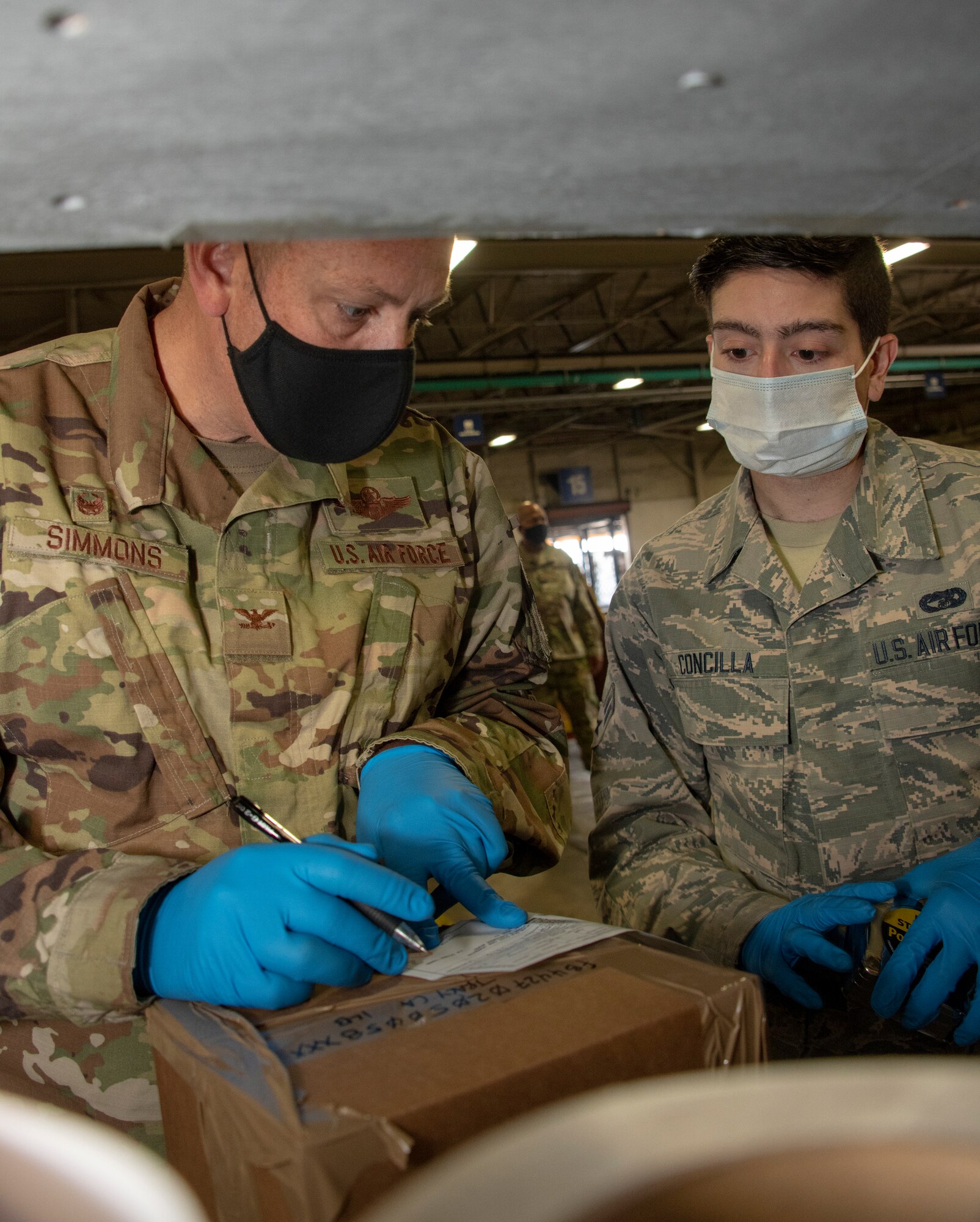 From left, U.S. Air Force Col. Corey Simmons, 60th Air Mobility Wing commander, Airman 1st Class Gregory Concilla, 60th Aerial Port Squadron packing and crating technician, Chief Master Sgt. Robert Schultz, 60th AMW command chief, and A1C Yaser Belal, 60th APS packing and crating technician, participate in a packing and crating demonstration during Leadership Rounds July 24, 2020, at Travis Air Force Base, California. The 60th APS is the United States Transportation Command's primary west coast aerial port providing global and passenger distribution for the United States and its Allies. The Leadership Rounds program provides 60th AMW leadership an opportunity to interact with Airmen and get a detailed view of each mission performed at Travis AFB.  (U.S. Air Force photo by Heide Couch)