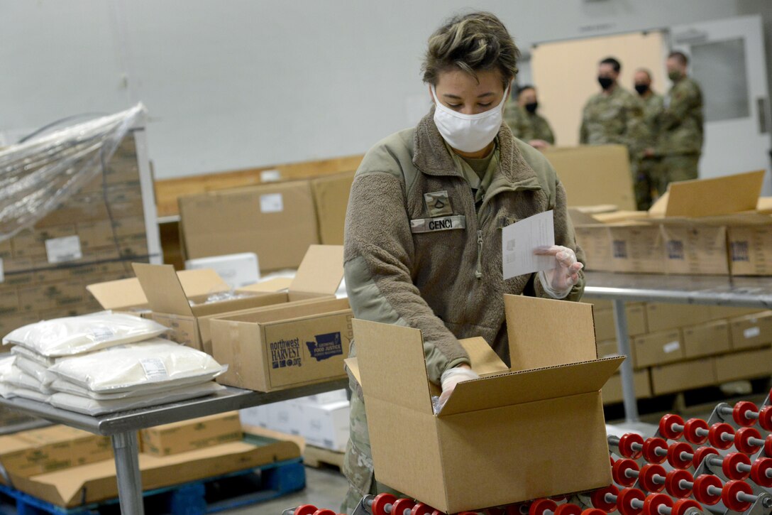 Washington National Guardsmen pack boxes of food for distribution.