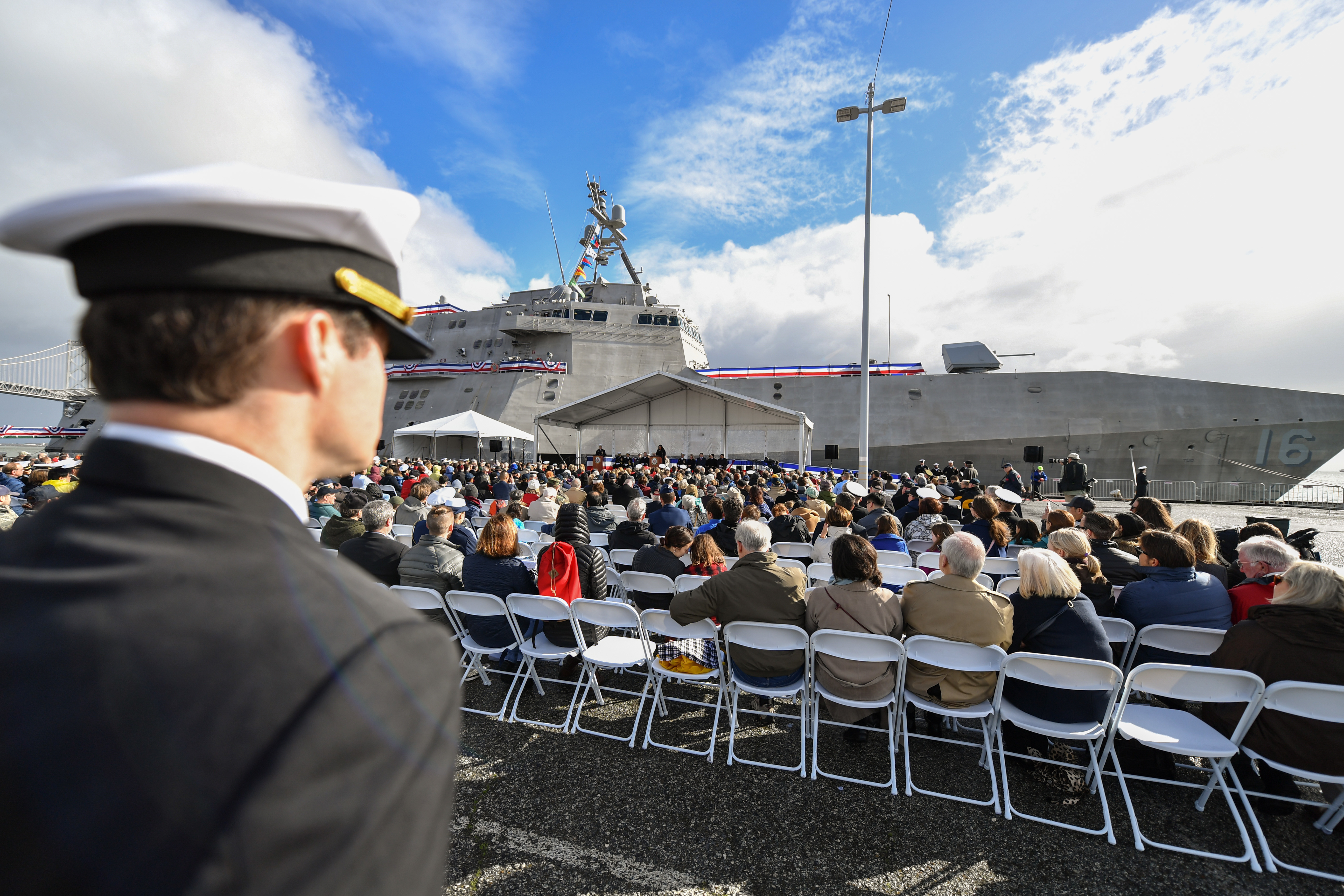 Sailor stands with guests sitting listening to the speech