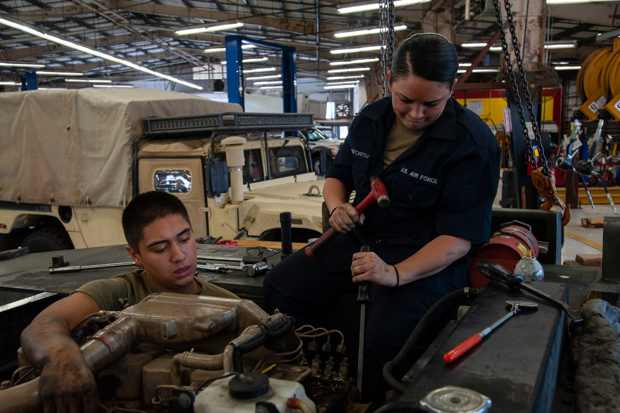 U.S. Air Force Airman 1st Class Sebastian Nucatola and Staff Sgt. Virginia Bludworth, 6th Logistics Readiness Squadron vehicle mechanics, work to access the fuel injection pump on an MB-2 aircraft tow tractor, July 15, 2020, at MacDill Air Force Base, Fla.
