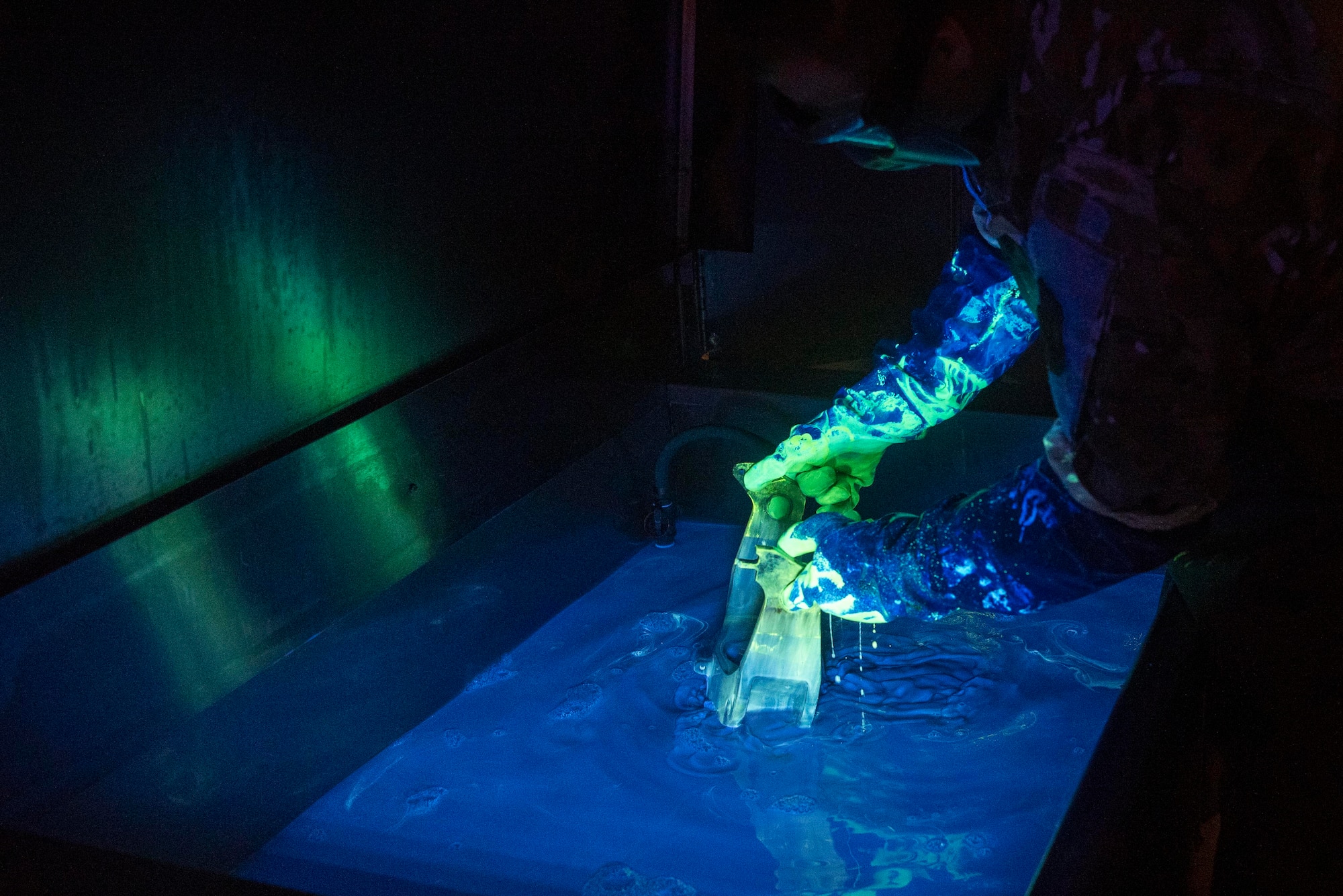 Airman 1st Class Triston Good-Bishop, 100th Maintenance Squadron non-destructive inspection apprentice, washes away penetrant from an aircraft part July 28, 2020, at RAF Mildenhall, England. The penetrant is used to identify cracks and imperfections, which ensures a corrupted aircraft component does not impede flight operations. (U.S. Air Force photo by Airman 1st Class Joseph Barron)